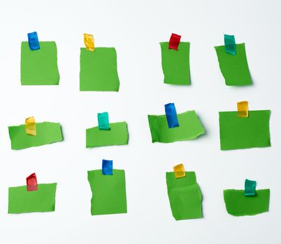 lot of torn green pieces of paper glued with scotch tape on a white background, place for text