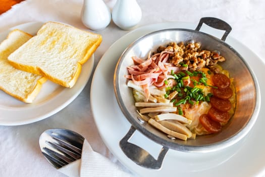 Breakfast with fried egg in a pan with bacon and bread background.