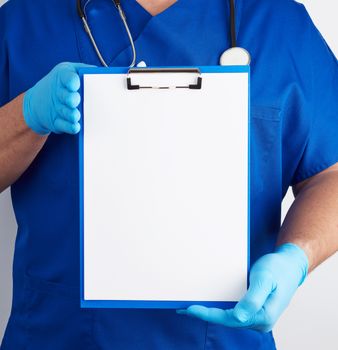 doctor in blue uniform and latex gloves holds a blue holder for sheets of paper, empty space for writing text, white background