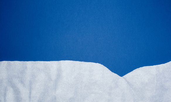 dark blue background with white crumpled torn paper elements, place for writing op in the middle, template