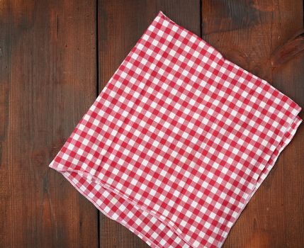 white red checkered kitchen towel on a brown wooden background, picnic background, copy space