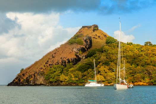 Yachts anchored at the Pigeon Island with fort ruin on the rock, Rodney bay, Saint Lucia, Caribbean sea