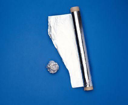 roll of gray foil for baking and packaging food on a dark blue background, torn edge