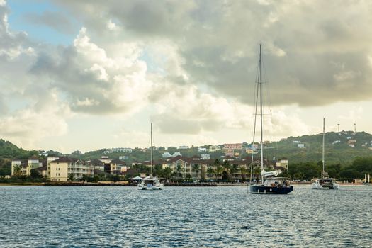 Offshore view of Rodney bay with yachts anchored in the lagoon and rich resorts in the background, Saint Lucia, Caribbean sea