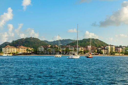 Offshore view of Rodney bay with yachts anchored in the lagoon and rich resorts in the background, Saint Lucia, Caribbean sea