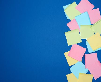 multicolored blank paper stickers of different colors on a dark blue background, copy space