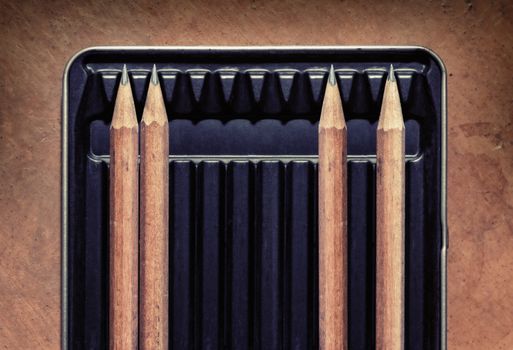 Wooden pencils in a box with spaces between them. Concept picture for social distancing.