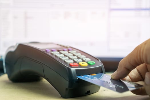 Insert Credit card POS terminal machine,closeup paying by credit cards in café. Focus on man hands inserting device for transfer buy shopping through electronic transaction machine in counter, mock up