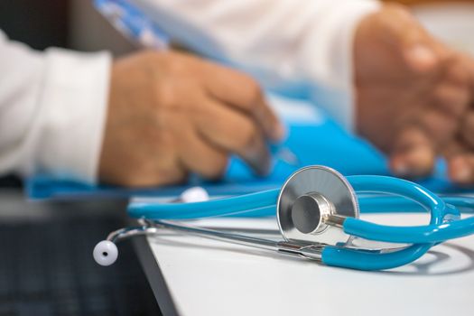 Medicine doctor hand writing prescription clipboard record information of patient in clinic, Female physician working on laptop computer and stethoscope in hospital. Healthcare and medical concept