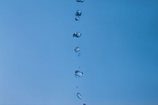 Water bubbles in the blue sky. Water drops on blue background. Aqua, rain, weather, clear. Life, freedom, ease.