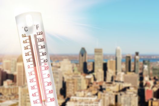 Thermometer in front of an urban skyline during heatwave