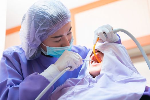 Dentistry and teeth healthcare concept at dental clinic. Dentist check-up teeth for young asian patient.