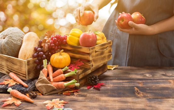 Fall harvest cornucopia. Farmer with fruit and vegetable in Autumn season. Thanksgiving day concept.