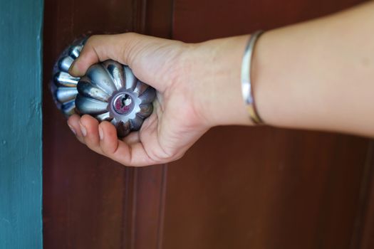 Hand holding the door knob to enter or exit the room.