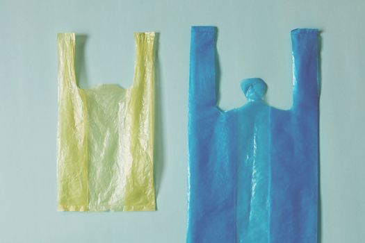 Empty plastic bag against light blue background for waste recycling concept