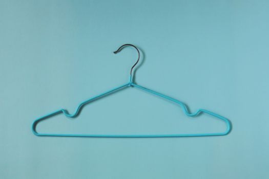 Clothes hangers on blue background for household items.