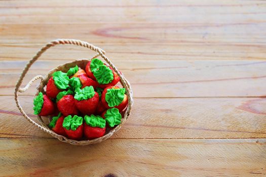 Strawberry shaped marshmallows with a scrumptious flavor in the basket on wooden background for food and sweet desserts concept