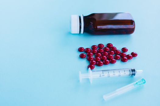 Blood tonic includes multivitamins, folic acid, and iron liquid with bottle and syringe injection on blue background for healthcare and medical concept