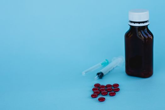 Blood tonic includes multivitamins, folic acid, and iron liquid with bottle and syringe injection on blue background for healthcare and medical concept