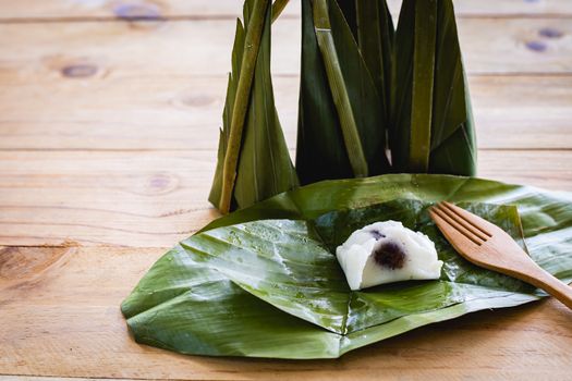 Steamed flour custard with sweet coconut filling on wooden background for Thai dessert concept