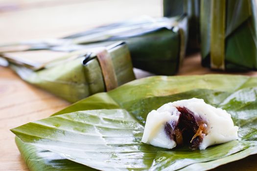 Steamed flour custard with sweet coconut filling on wooden background for Thai dessert concept