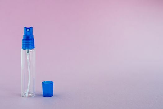 Transparent glass perfume and cosmetic spray bottle on pink background for product packaging concept