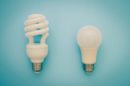Fluorescent and LED light bulb on blue background for energy savings concept
