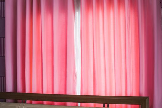 Pink curtains with sunlight through the window for decoration and interiors concept