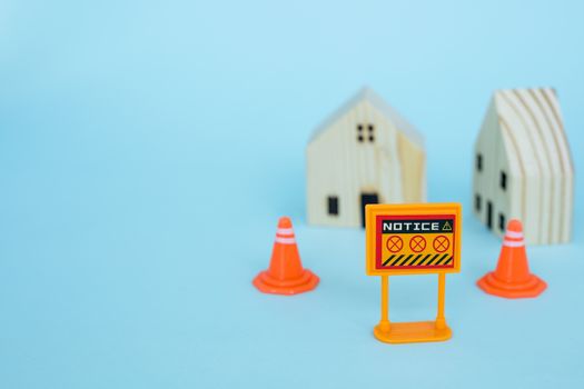 Prohibition sign with blurred wooden house model on blue background for self-quarantine and staying home in coronavirus or Covid-2019 situation concept