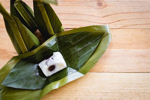 Steamed flour custard with sweet coconut filling on wooden background for Thai dessert concept