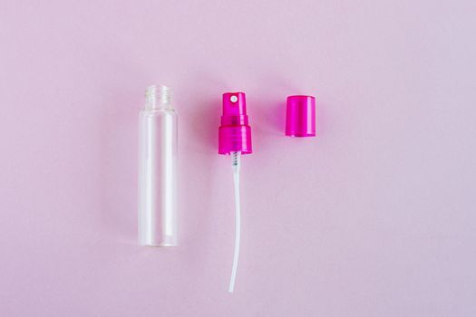 Transparent glass perfume and cosmetic spray bottle on pink background for product packaging concept