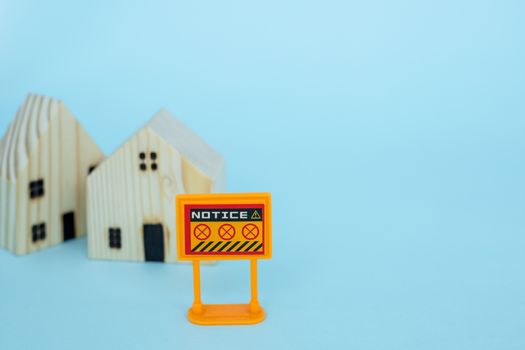 Prohibition sign with blurred wooden house model on blue background for self-quarantine and staying home in coronavirus or Covid-2019 situation concept