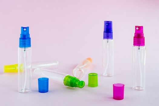 Transparent glass perfume and cosmetic spray bottle on pink background for product packaging concept