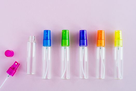 Transparent glass perfume and cosmetic spray bottle on pink background for product packaging concept