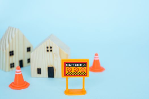 Prohibition sign with blurred wooden house model on blue background for self-quarantine and staying home in coronavirus or Covid-2019 situation concept