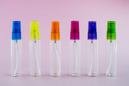 Transparent glass perfume and cosmetic spray bottle on pink background for product packaging concept