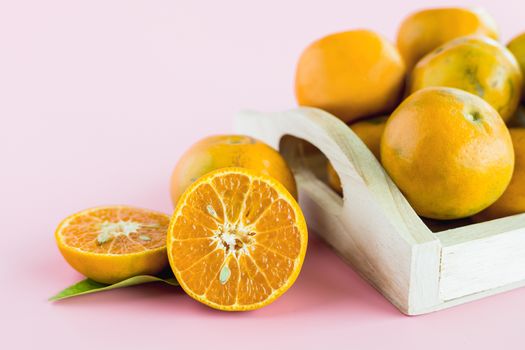 Orange in the wooden box on pink background for fruit and eating concept