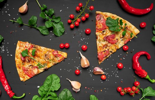 triangular piece of baked pizza with mushrooms, smoked sausages, tomatoes and cheese, black background, flat lay