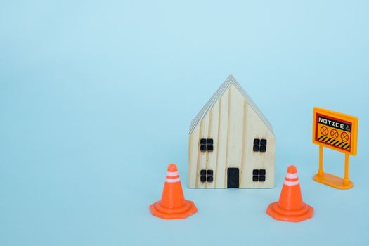 Prohibition sign with wooden house model on blue background for self-quarantine and staying home in coronavirus or Covid-2019 situation concept