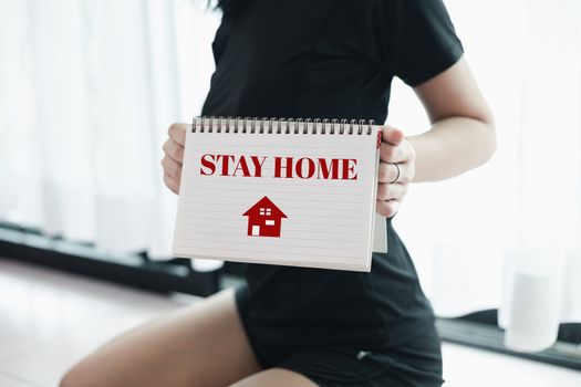 Woman's hand holding paper with alert message for self-quarantine, staying home and social distancing in coronavirus or Covid-2019 outbreak situation concept