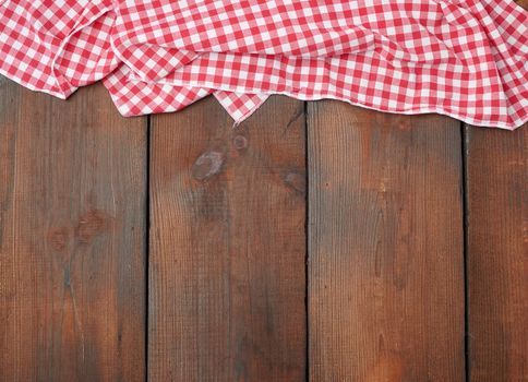 white red checkered kitchen towel on a brown wooden background, picnic background, copy space