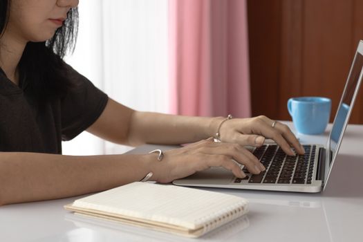 Woman using computer laptop and working at home for business, self-quarantine, staying home and social distancing in coronavirus or Covid-2019 outbreak situation concept