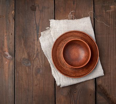 empty brown ceramic plates on a wooden table, top view