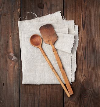 wooden old spoon and spatula on a gray linen napkin, top view