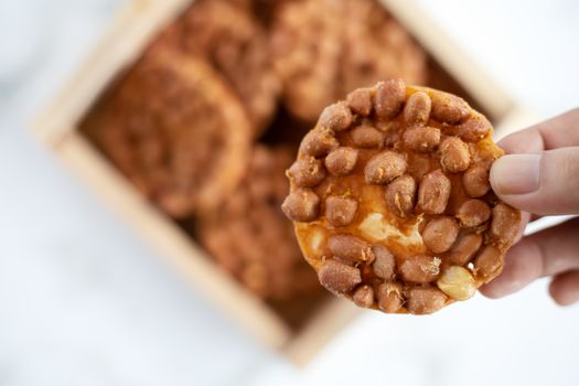 Hand holding Thai fried peanut cookies for asian dessert, food and eating concept