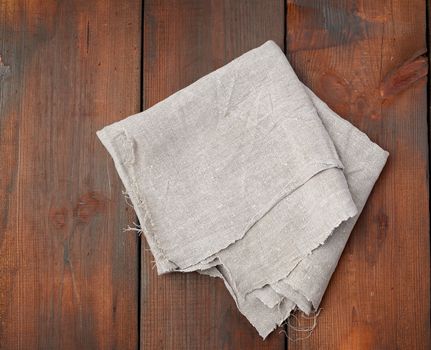 folded gray linen towel on wooden background, top view, copy space