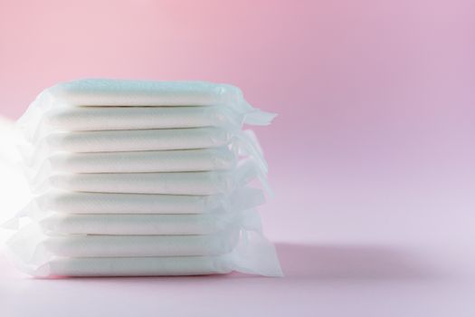 Feminine sanitary napkin, an absorbent item worn by a woman while menstruating, on pink background for hygiene and health concept