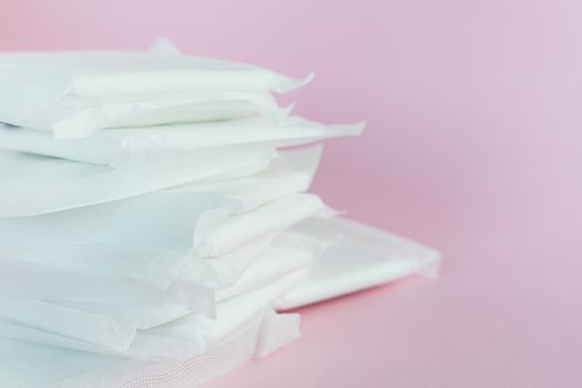 Feminine sanitary napkin, an absorbent item worn by a woman while menstruating, on pink background for hygiene and health concept