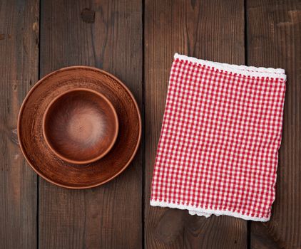 empty brown ceramic plates on a wooden table, top view