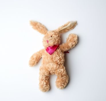 toy brown plush hare lies on a white background, top view